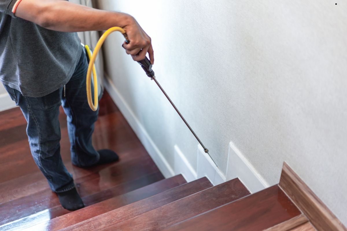 A man vacuums the stairs, showcasing the importance of cleanliness in homes with termite-proof flooring services.